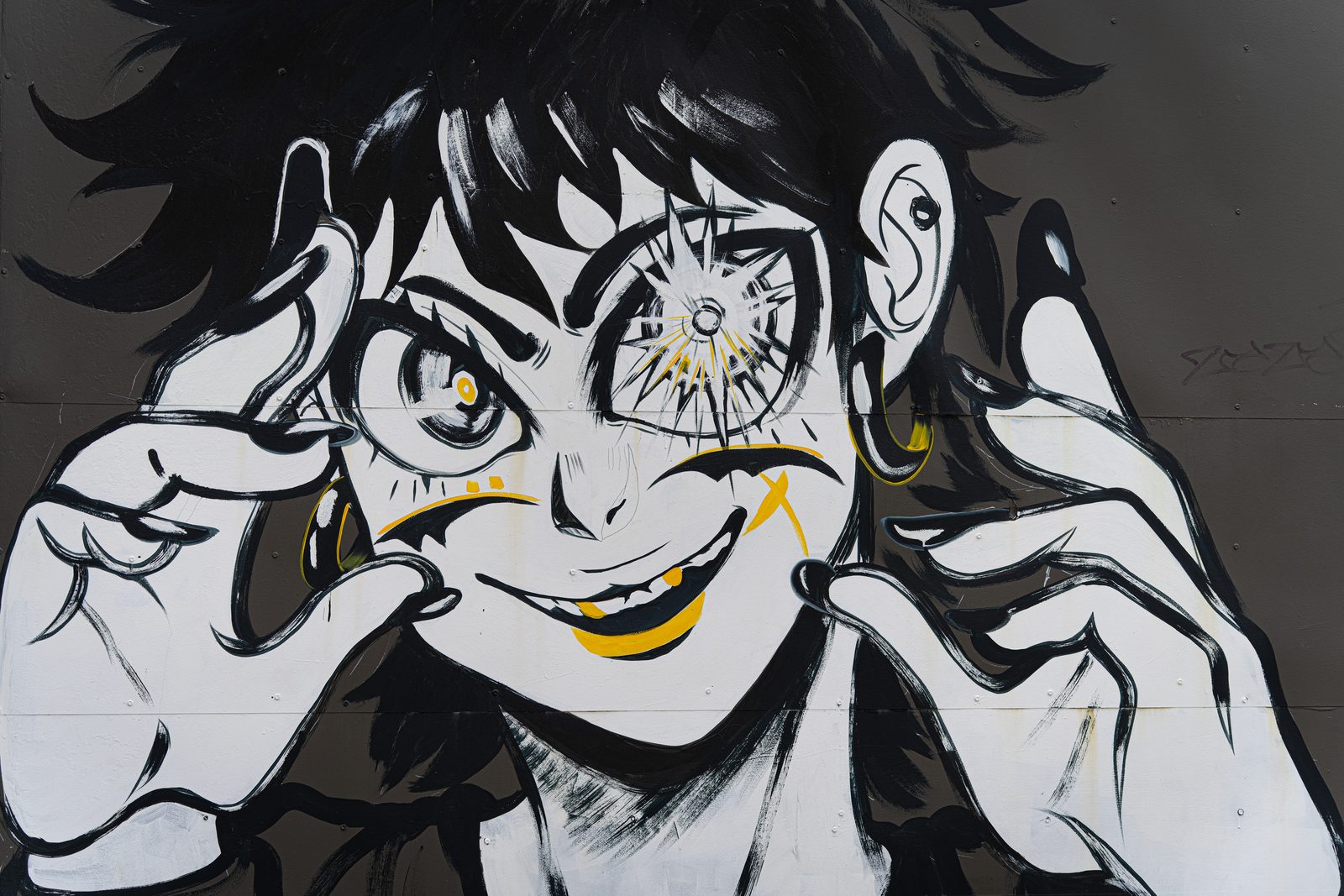 Fresque de street art à Miami : personnage style manga en noir et blanc tirant sur sa paupière, touches de jaune, grimace espiègle